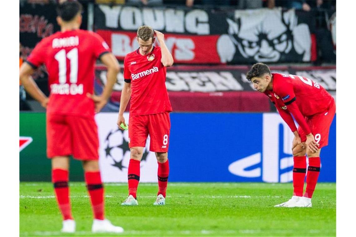 Bayers brotlose Kunst - Tahs Disput mit Fan Kai Havertz (r-l) und Lars Bender und Leverkusens Nadiem Amiri (l) sind nach der Niederlage enttäuscht. Foto: Rolf Vennenbernd
