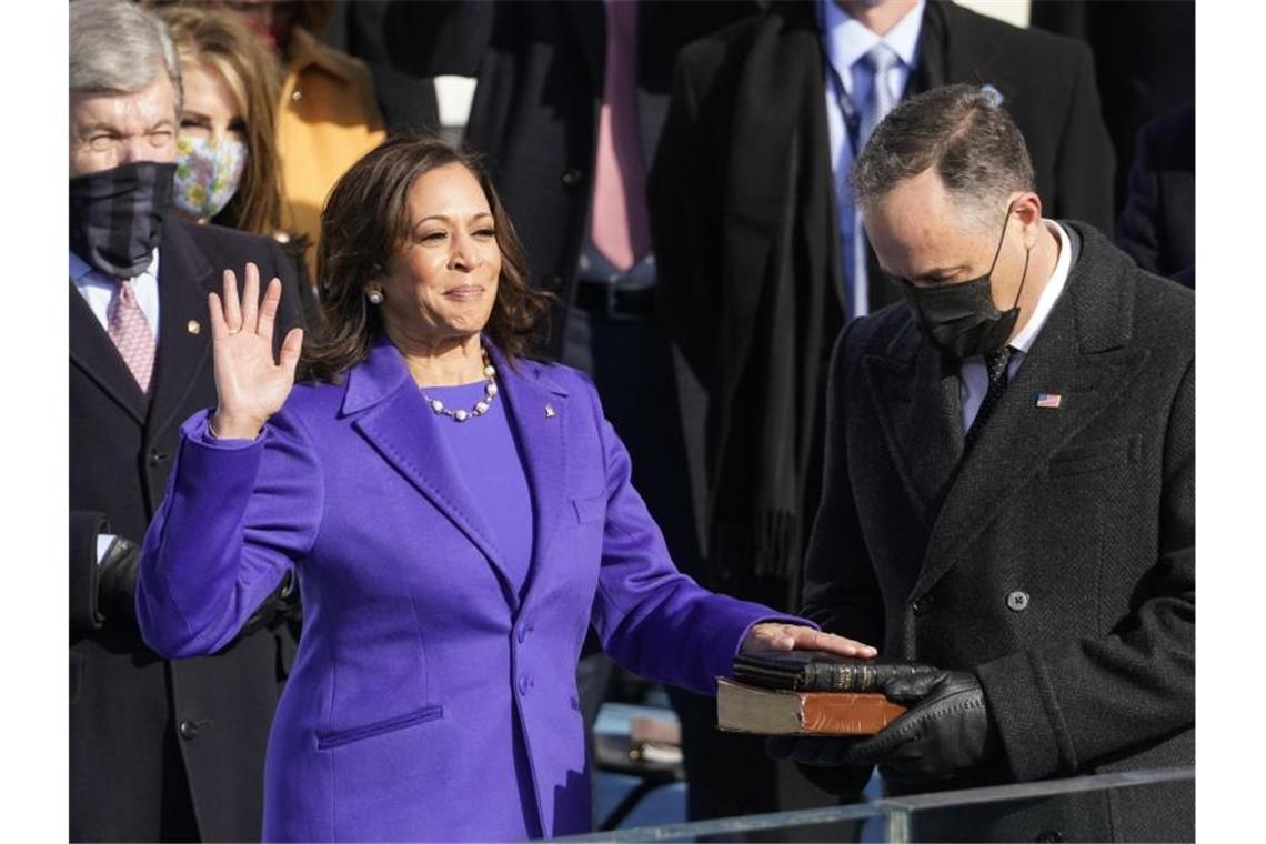 Kamala Harris wird als erste US-Vizepräsidentin vereidigt, während ihr Ehemann Doug Emhoff die Bibel hält. Foto: Andrew Harnik/AP/dpa
