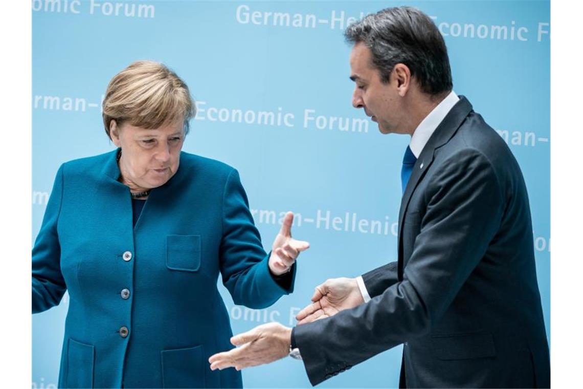 Kanzlerin Angela Merkel begrüßt Kyriakos Mitsotakis, Premierminister von Griechenland, zu Beginn des Deutsch-Griechischen Wirtschaftsforums. Foto: Michael Kappeler/dpa