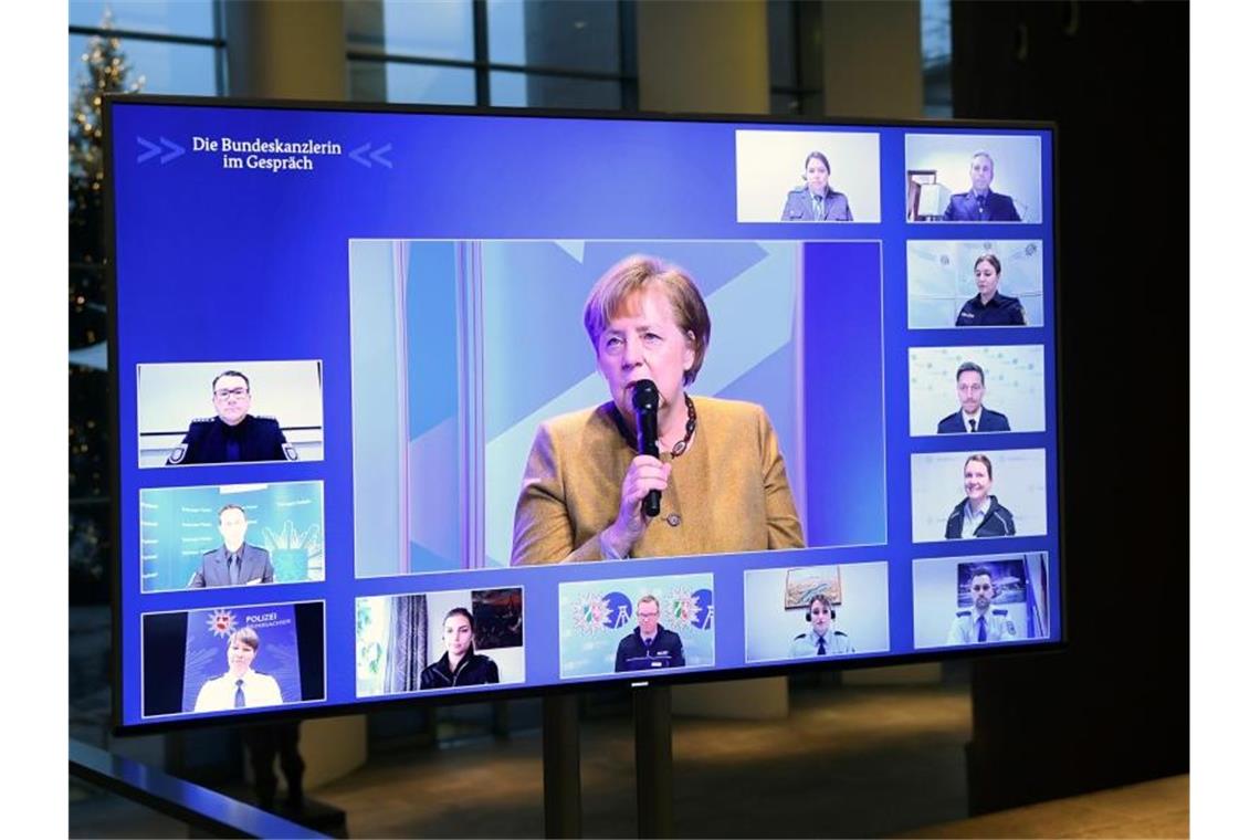 Kanzlerin Angela Merkel spricht mit Polizeibeamten und Polizeibeamtinnen. Foto: Annegret Hilse/Reuters Images Europe/Pool/dpa