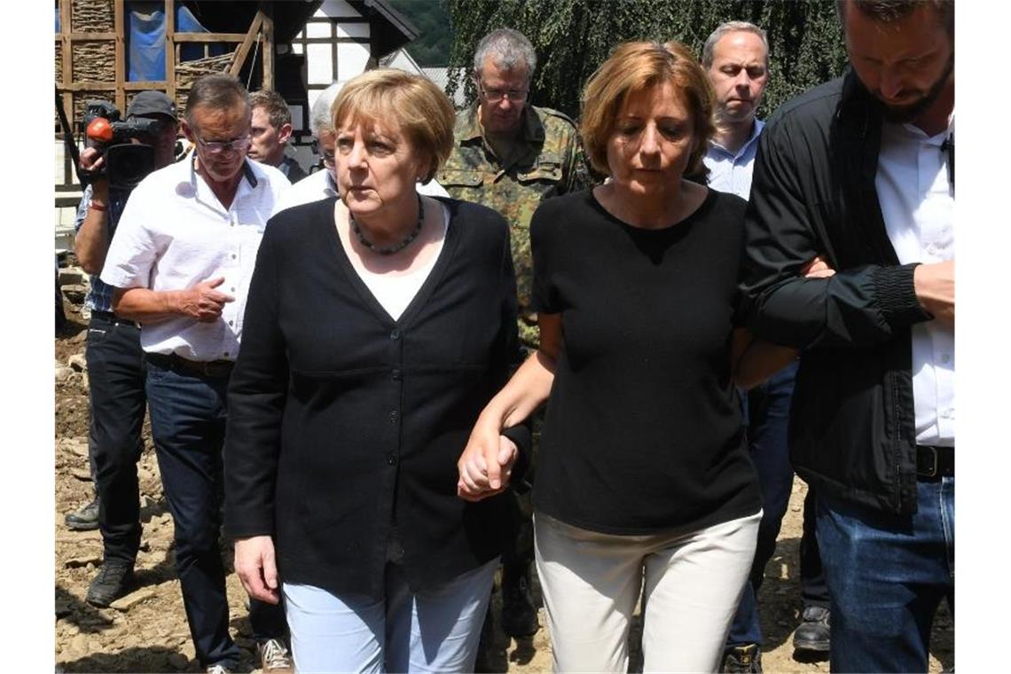 Merkel: „Gespenstische Situation“ im Katastrophengebiet Kanzlerin im Katastrophengebiet: Begleitet von Rheinland-Pfalz' Ministerpräsidentin Malu Dreyer hat Angela Merkel den Hochwasser-Hotspot Schuld besucht. Foto: Christof Stache/POOL AFP/dpa