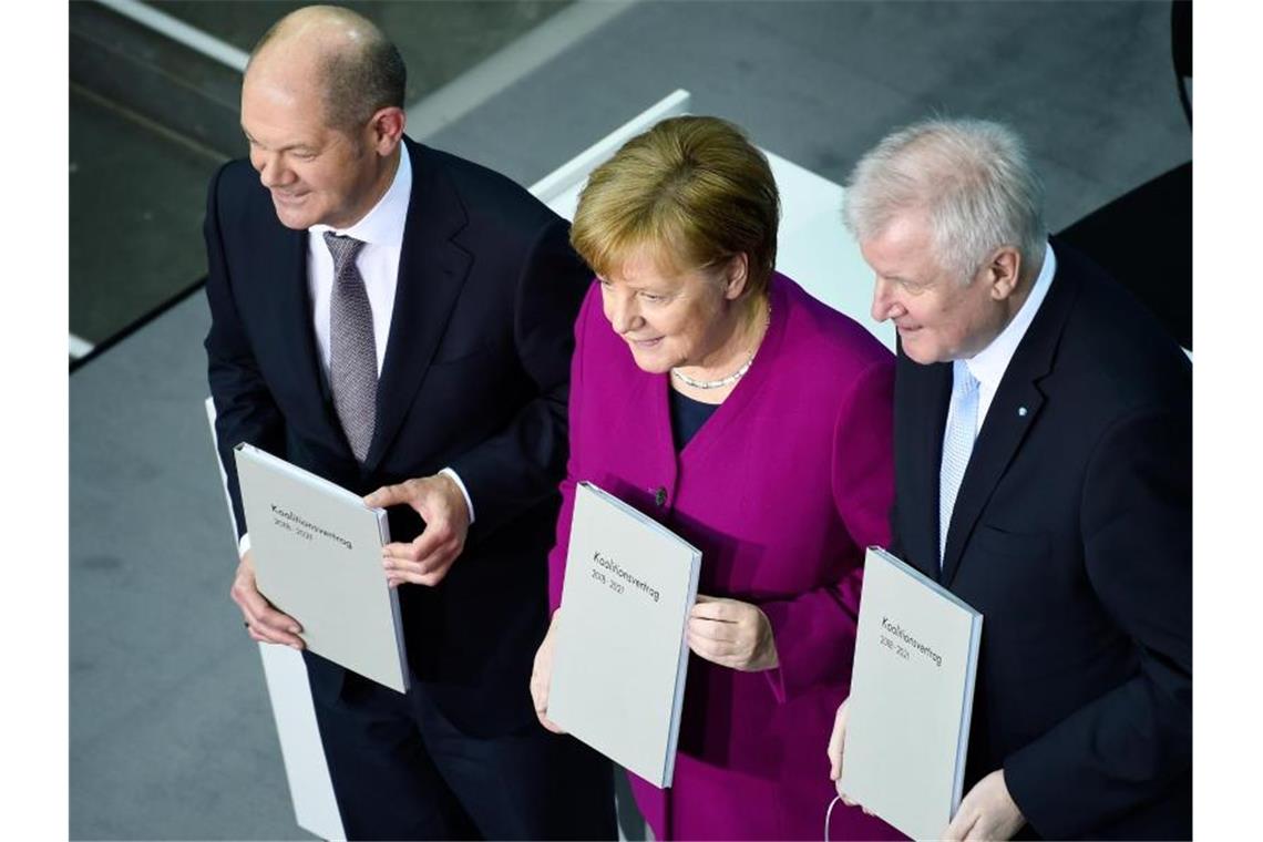 Koalition will Anfang November Zwischenbilanz ziehen Kanzlerin Merkel, CSU-Chef Seehofer (r) und der damalige kommissarische SPD-Vorsitzende Scholz präsentieren im März 2018 den Koalitionsvertrag. Foto: Gregor Fischer/dpa