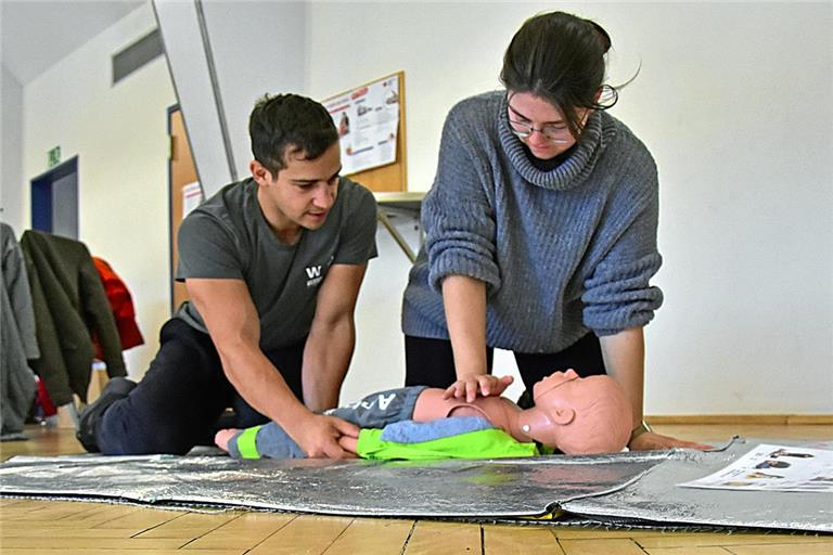 Karim El Azzazy und seine Partnerin Sonja Volkmer üben beim DRK-Kurs in der Gemeindehalle in Jux an einer Babypuppe lebensrettende Sofortmaßnahmen, hier eine Druckmassage. Foto: Tobias Sellmaier
