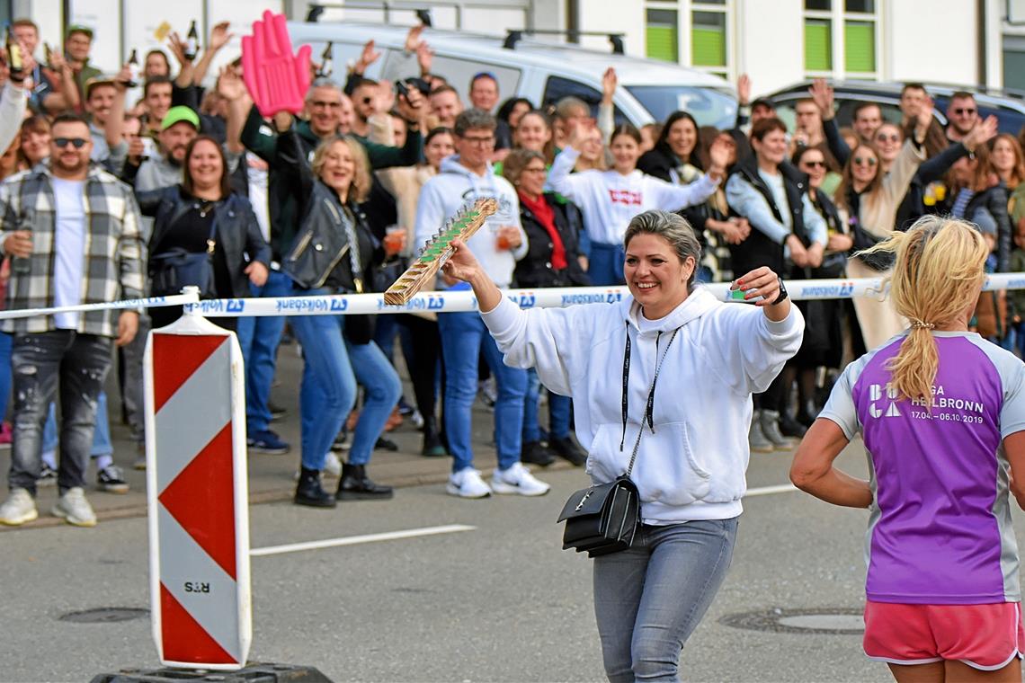 Backnanger Silvesterlauf: Ein starker Schluck gegen die Durststrecke Karin Röhrle verteilt in der Talstraße unter lautstarker Unterstützung der Zuschauer die Getränke. Foto: Tobias Sellmaier