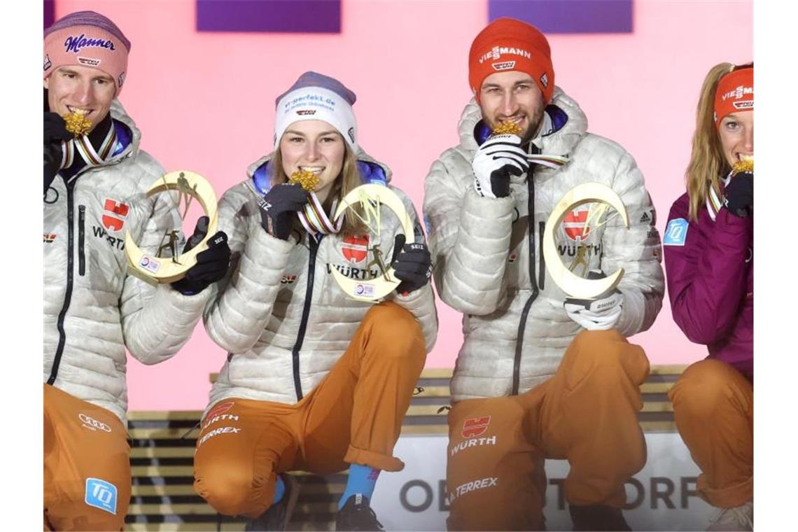 Karl Geiger (l-r), Anna Rupprecht, Markus Eisenbichler und Katharina Althaus gewinnen Skisprung-Mixed-WM-Gold in Oberstdorf. Foto: Karl-Josef Hildenbrand/dpa
