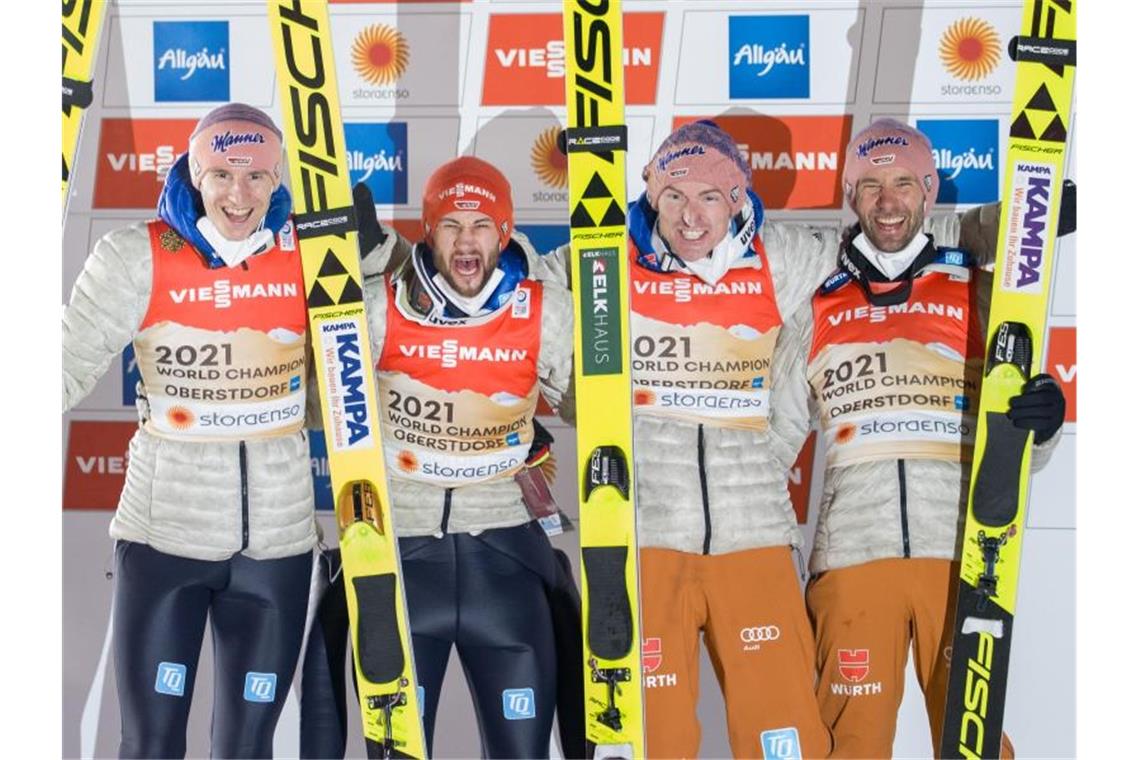 Karl Geiger (l-r), Markus Eisenbichler, Severin Freund und Pius Paschke jubeln über die erfolgreiche Titelverteidigung. Foto: Daniel Karmann/dpa