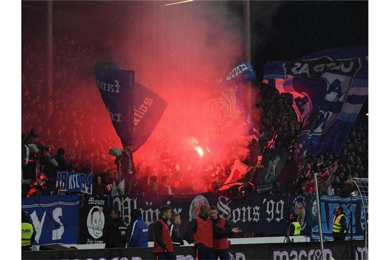 Karlsruher Fans brennen Pyrofackeln ab. Foto: Uli Deck/dpa/Archivbild
