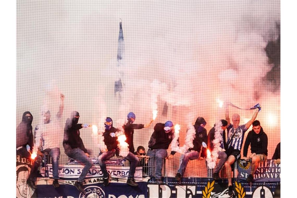 Karlsruher Fans zünden Pyrotechnik vor Beginn des Spiels gegen Erzgebirge Aue. Foto: Robert Michael/dpa/Archivbild