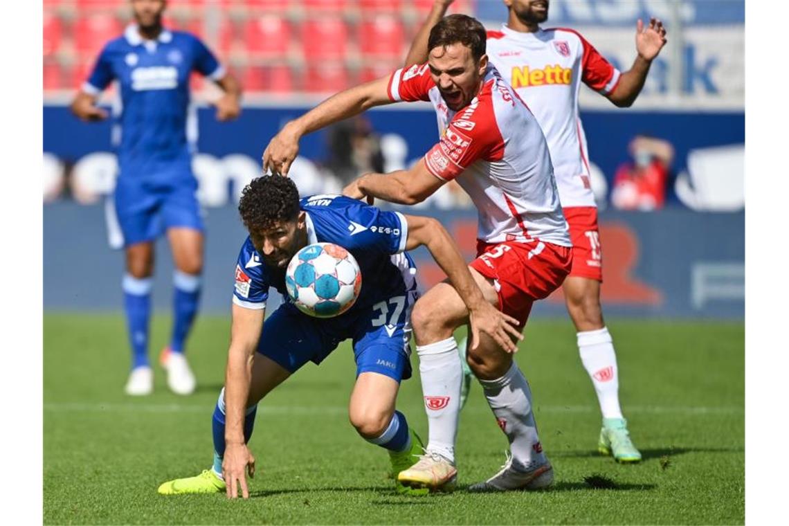 Terodde stellt Tor-Rekord ein - St. Pauli spitze Karlsruhes Fabio Kaufmann (l) versucht den Ball vor Regensburgs Benedikt Gimber zu behaupten. Foto: Armin Weigel/dpa