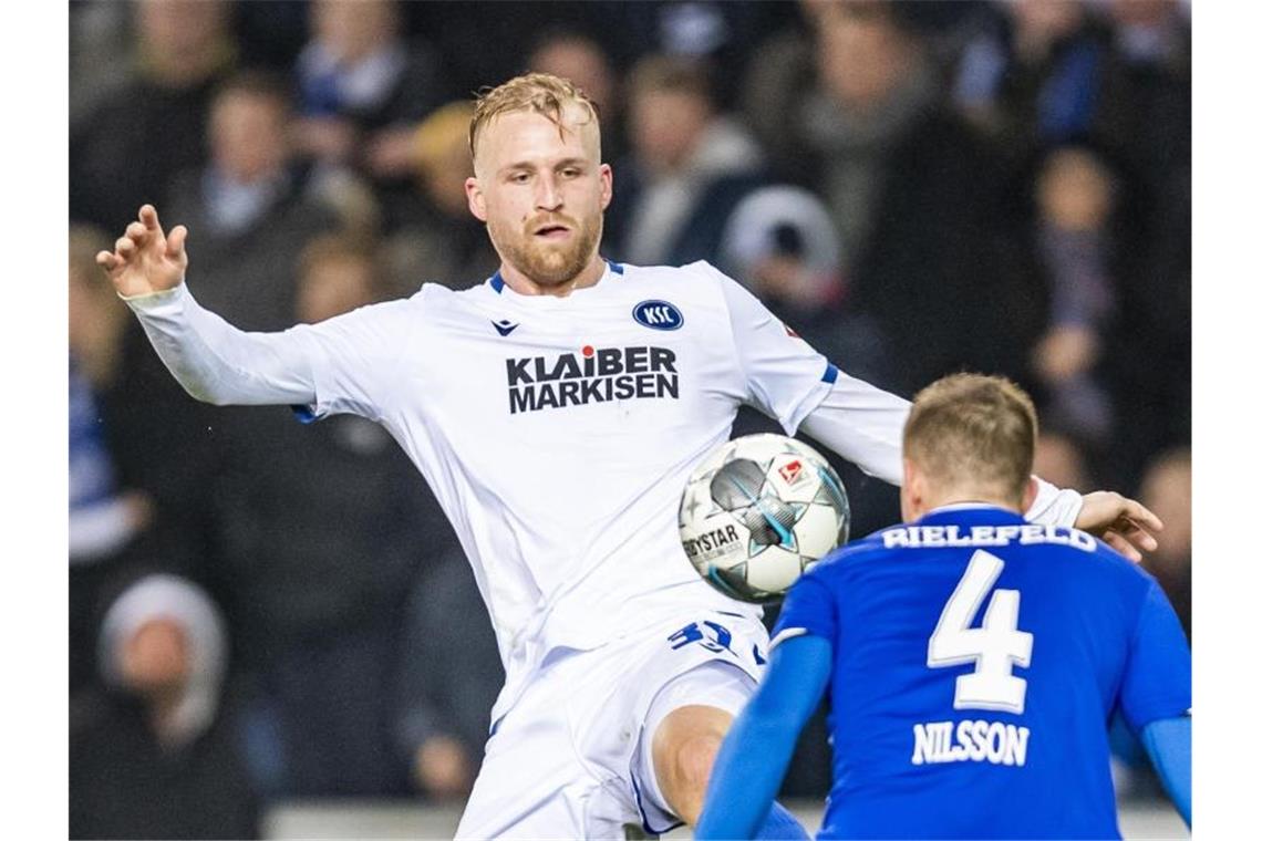 Karlsruhes Philipp Hofmann (l.) kämpft um den Ball. Foto: David Inderlied/dpa/Archivbild