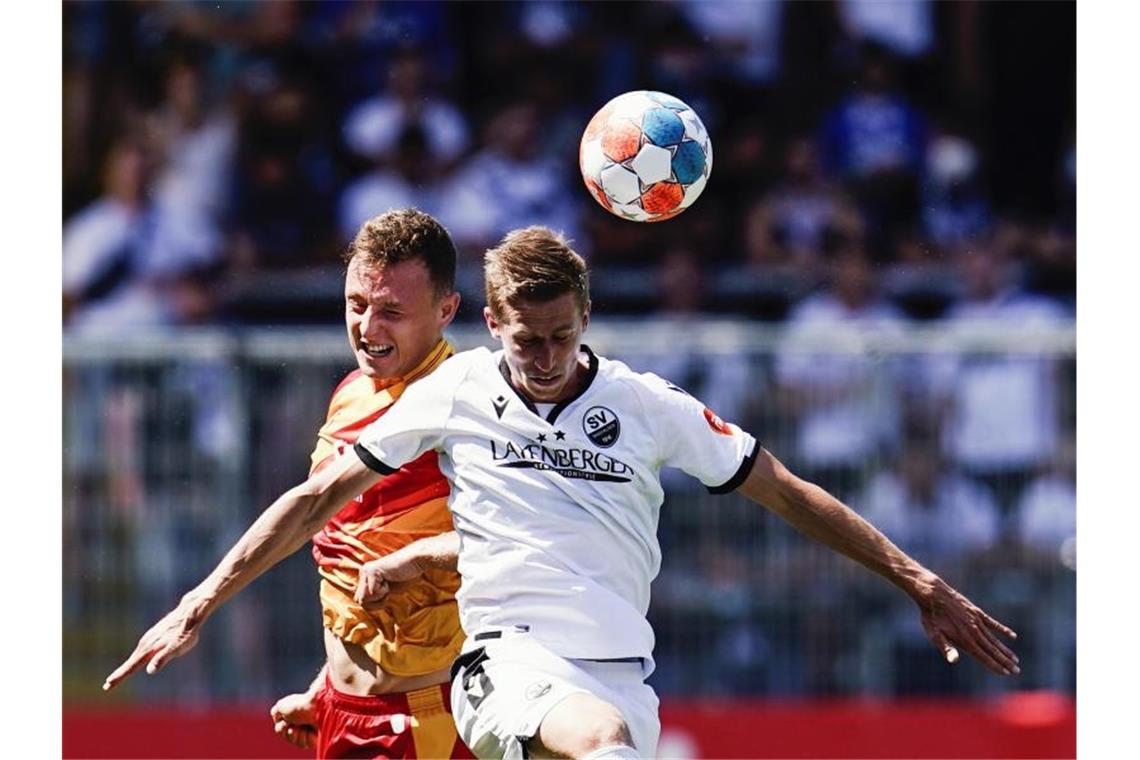 Karlsruhes Robin Bormuth (l) und Sandhausens Arne Sicker kämpfen um den Ball. Foto: Uwe Anspach/dpa/Archiv