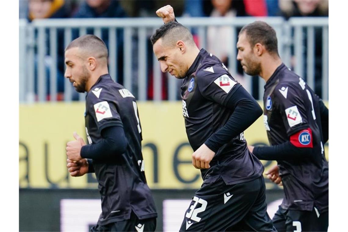 Karlsruhes Torschütze Änis Ben-Hatira (M) jubelt über das Tor zum 0:2. Foto: Uwe Anspach/dpa