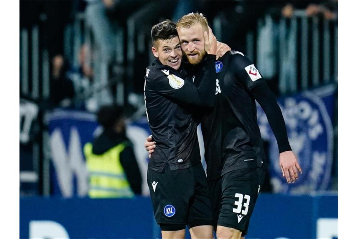 Karlsruhes Torschütze Philipp Hofmann (r) jubelt mit Karlsruhes Marvin Wanitzek über das Tor zum 0:1. Foto: Uwe Anspach/dpa