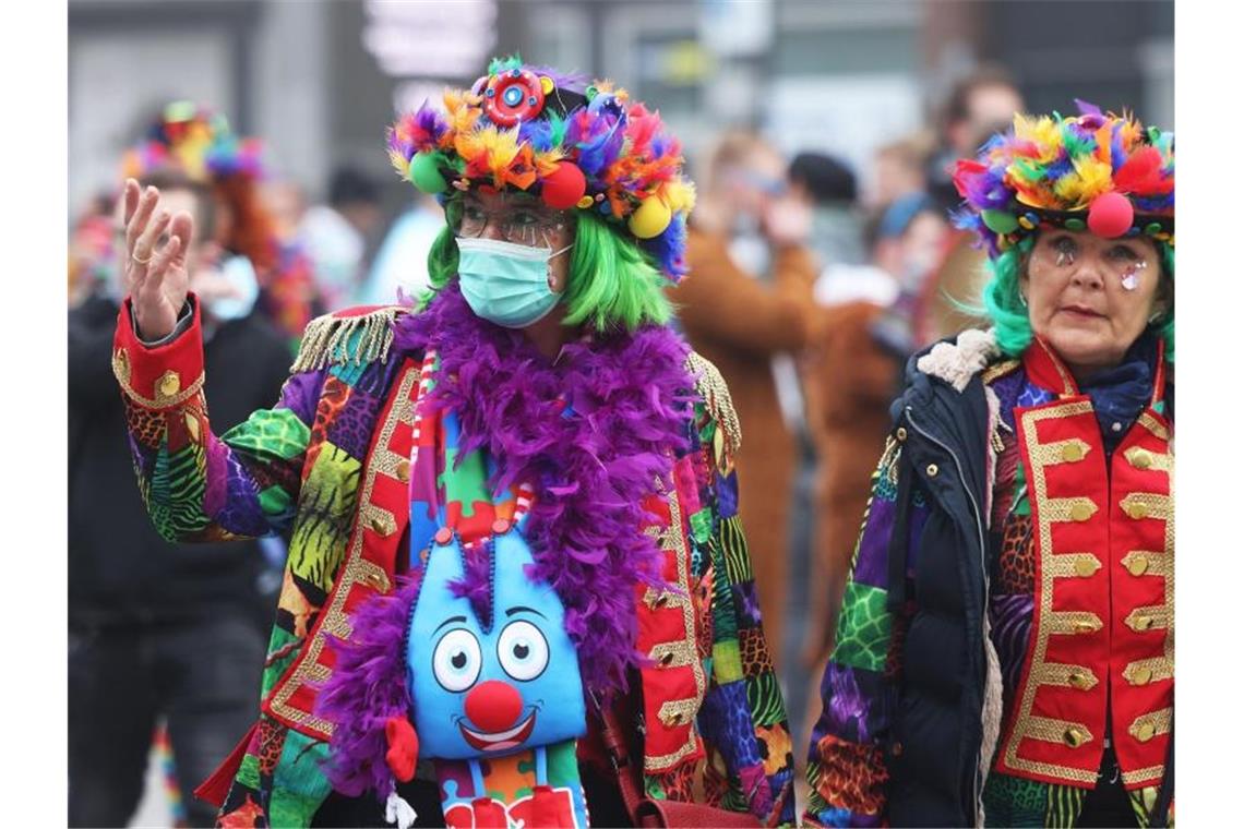 Karnevalistinnen in Köln: eine mit Maske, eine ohne. Foto: Oliver Berg/dpa