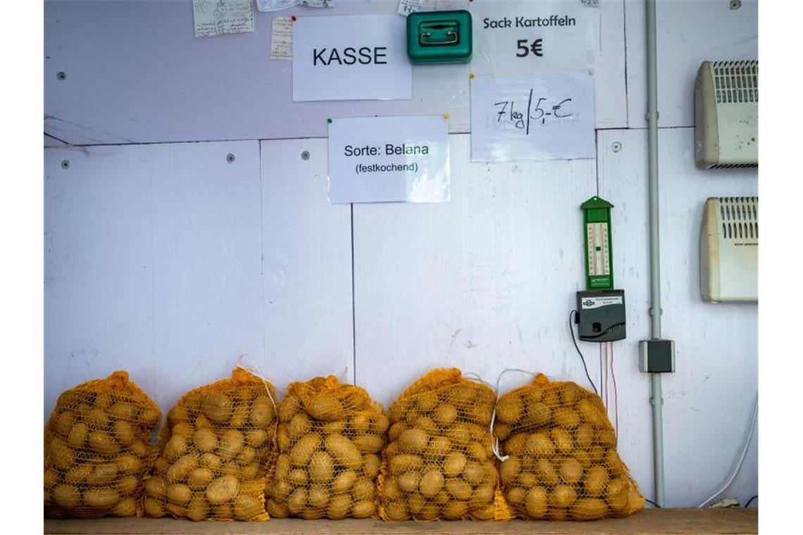 Kartoffeln stehen in einen Verkaufsstand bei einem Landwirt auf dessen Hof. Foto: Philipp Schulze/dpa