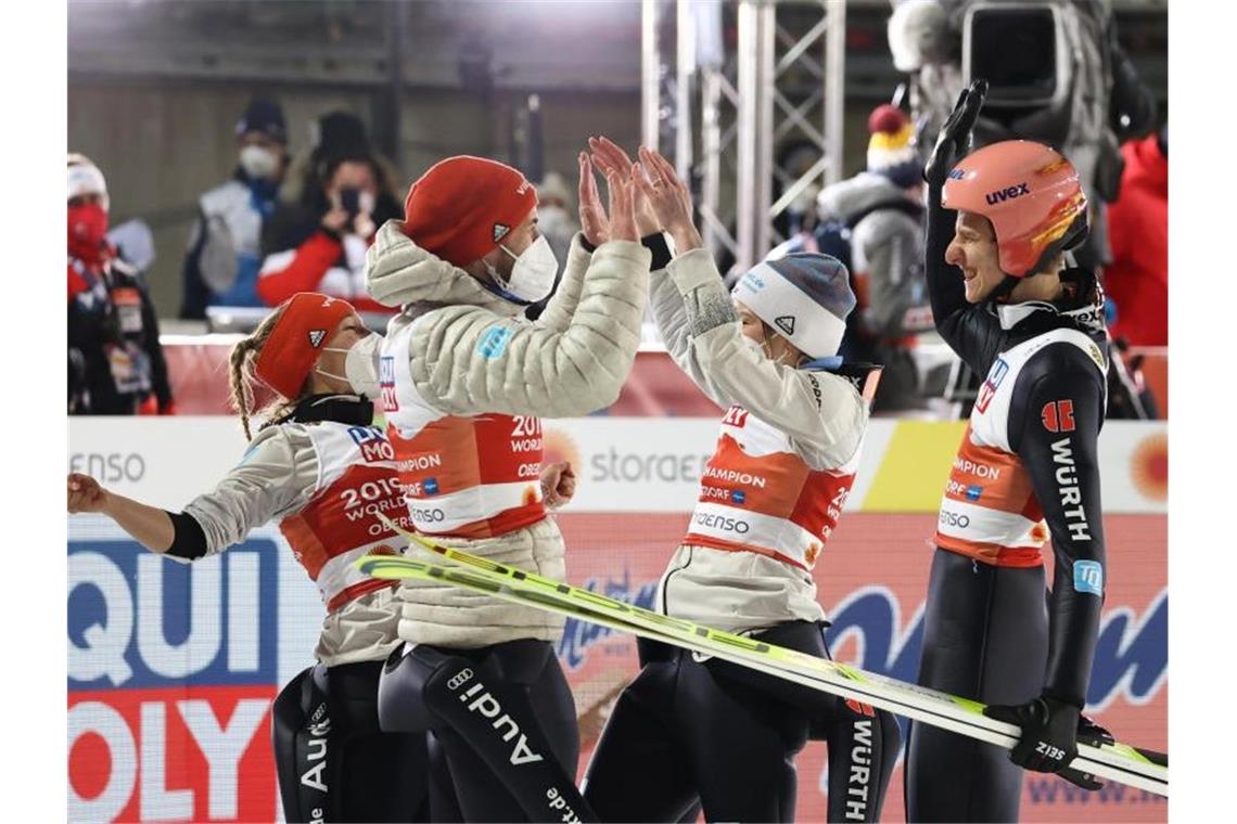 Katharina Althaus, Markus Eisenbichler, Anna Rupprecht und Karl Geiger (l-r) feiern ihren Gold-Triumph bei der Heim-WM in Oberstdorf. Foto: Daniel Karmann/dpa