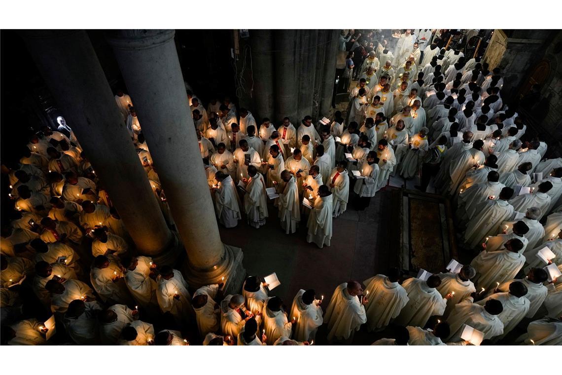 Katholische Geistliche halten Kerzen, während sie während der Prozession am Gründonnerstag zur Fußwaschung in der Grabeskirche in Jerusalem gehen.