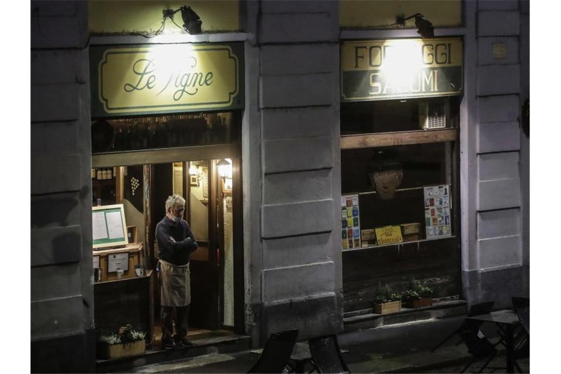 Kaum Gäste am Abend: Der Besitzer eines Restaurants in Rom schaut auf die Straße. Foto: Luca Bruno/AP/dpa