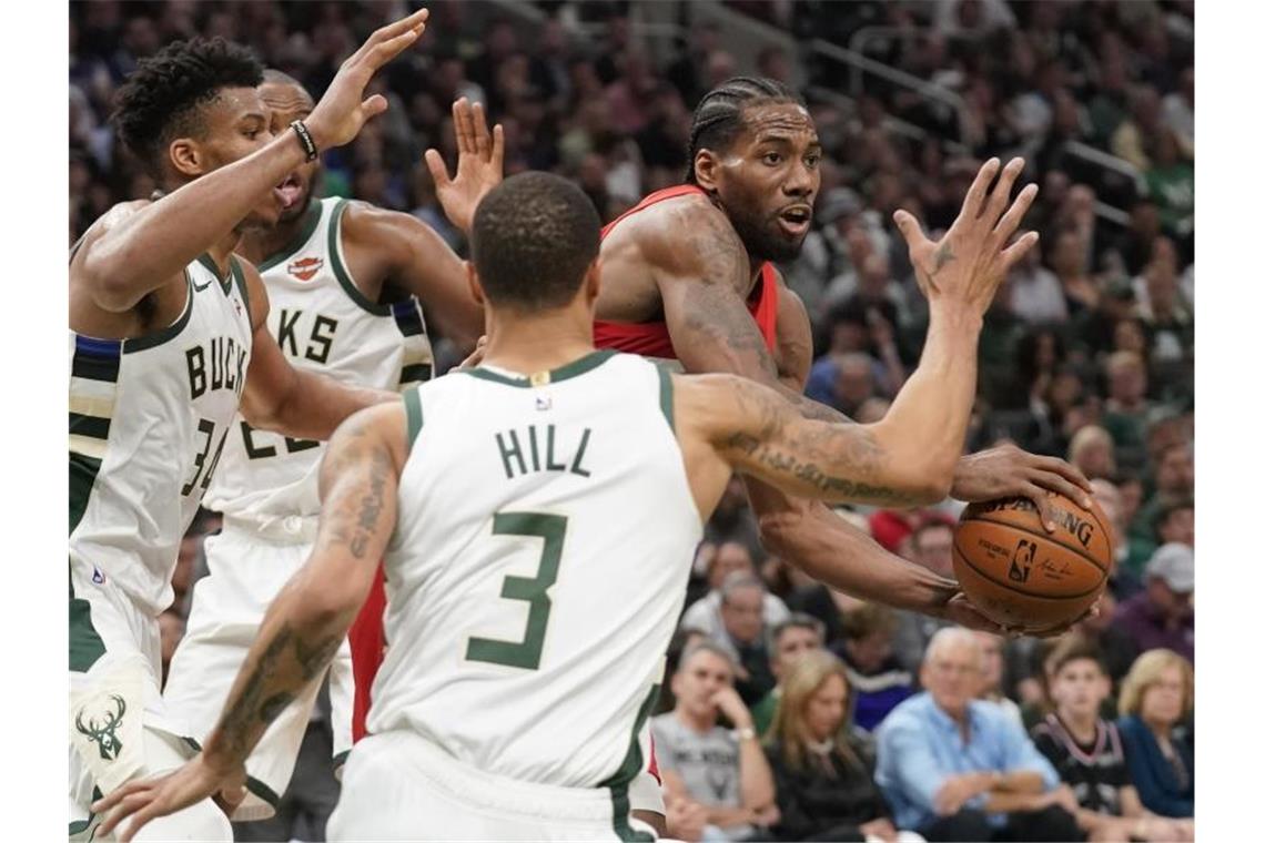 Kawhi Leonard (r) setzt sich gleich gegen drei Gegenspieler durch. Foto: Morry Gash/AP