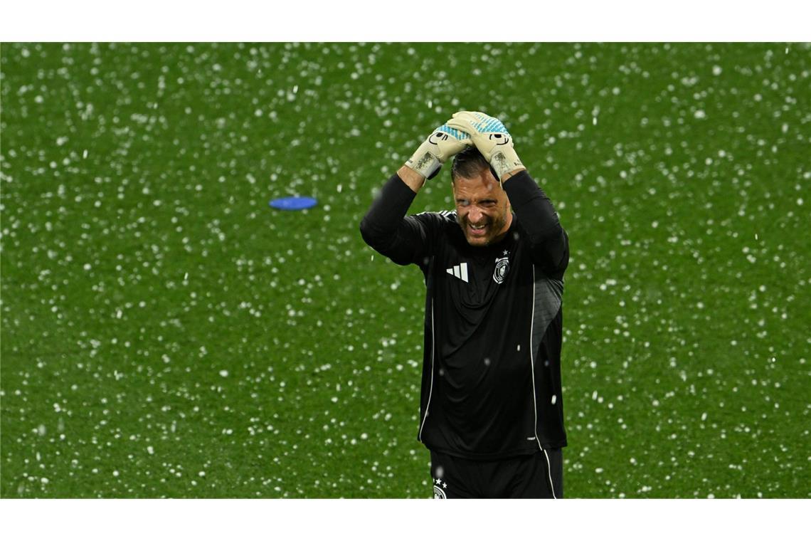 Bilder des Tages Kein Fußballwetter: Oliver Baumann, Torhüter von Deutschland, schützt beim Fußball-Länderspiel gegen Portugal in München seinen Kopf mit den Händen vor Hagel.
