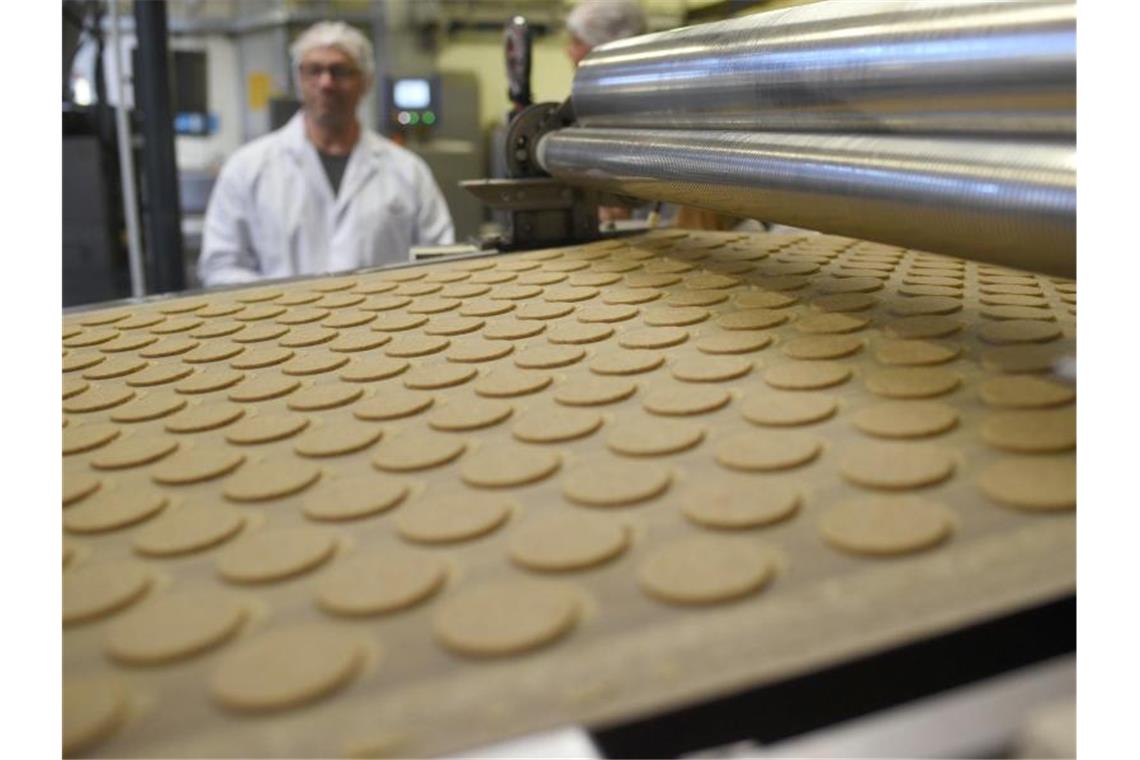 Kekse liegen bei einer Werksführung in der Printen-und Schokoladenfabrik Henry Lambertz GmbH & Co. KG auf einem Band. Die US-Strafzölle belasten auch die Deutsche Süßwarenindustrie. Foto: picture alliance / dpa