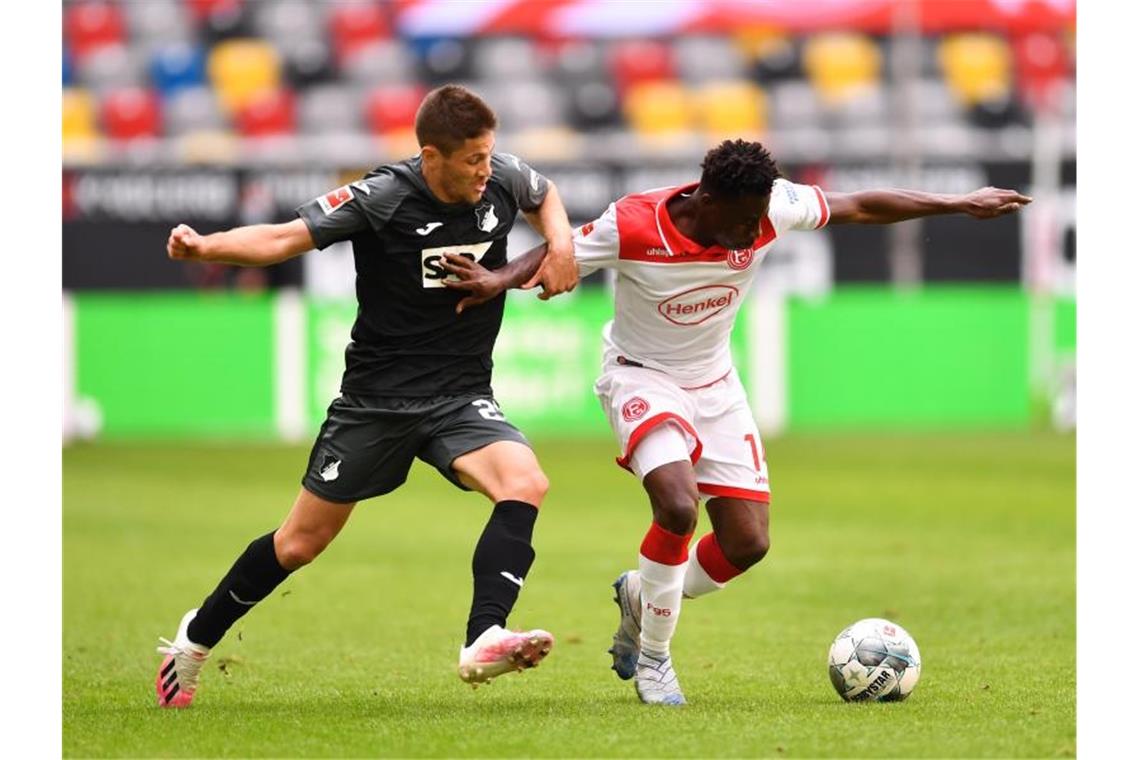 Kelvin Ofori (r) von Düsseldorf in Aktion gegen Andrej Kramaric von Hoffenheim. Foto: Marius Becker/dpa-Pool/dpa