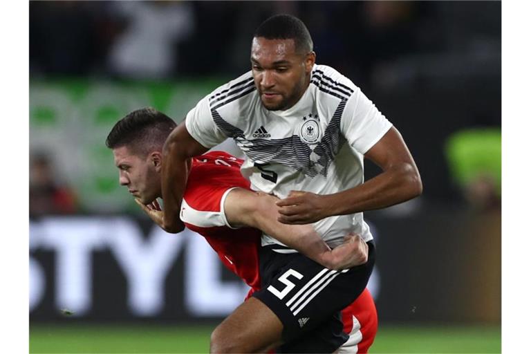 Kennen sich gut aus der Bundesliga: Jonathan Tah (r) ringt mit dem Serben Luka Jovic um den Ball. Foto: Christian Charisius