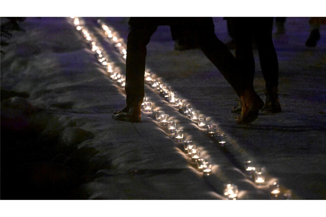 Kerzen in einer symbolischen Loipe erinnern an Laura Dahlmeier.