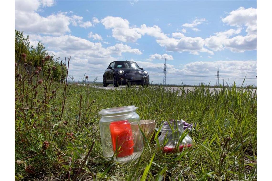 Kerzen und Blumen sind an einer Unfallstelle an einer Landstraße aufgestellt. Foto: Andreas Rosar