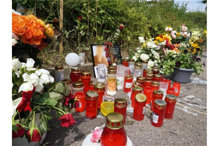 Kerzen und Blumen stehen am Tatort um ein Porträt des dort getöteten Mannes herum. Foto: Andreas Rosar