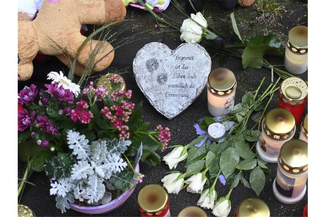 Kerzen und Blumen: Vor dem Haus fand eine kleine Trauerfeier statt. Foto: Roberto Pfeil/dpa