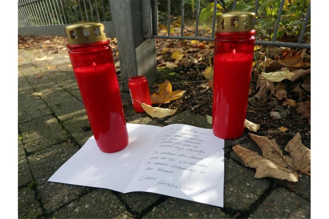 Kerzen und ein Brief liegen vor dem Gelände in Duisburg, auf dem ein Mädchen tot aufgefunden wurde. Foto: David Young/dpa