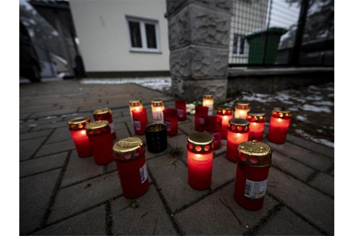 Fünf Tote in Brandenburg - Verbrechen gibt Rätsel auf Kerzen vor dem Einfamilienhaus in Königs Wusterhausen, in dem die Toten gefunden wurden. Foto: Fabian Sommer/dpa