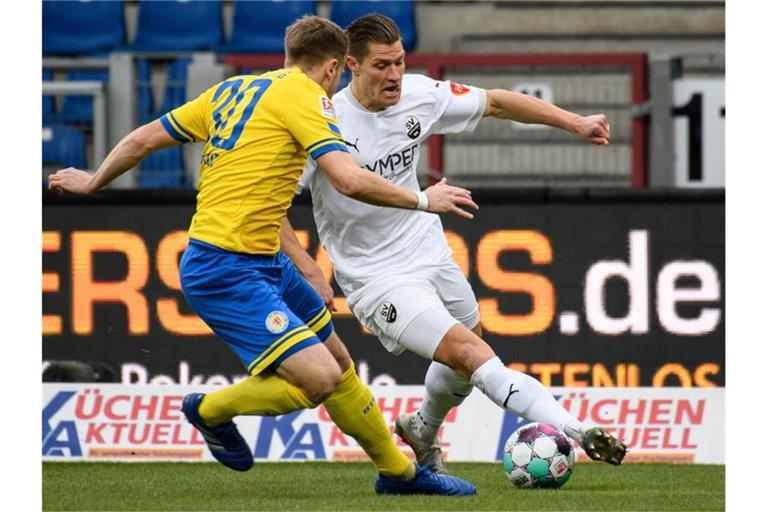 Kevin Behrens (r) vom SV Sandhausen kämpft mit Braunschweigs Brian Behrendt um den Ball. Foto: Swen Pförtner/dpa/Archivbild