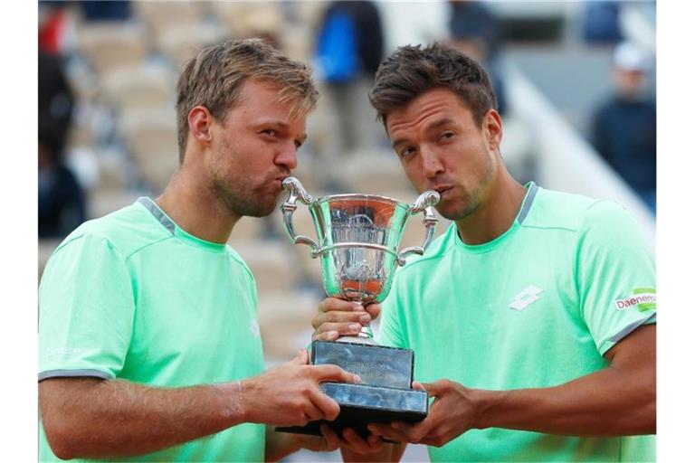 Kevin Krawietz (l) und Andreas Mies feiern ihren historischen Doppelsieg in Paris. Foto: Pavel Golovkin/AP