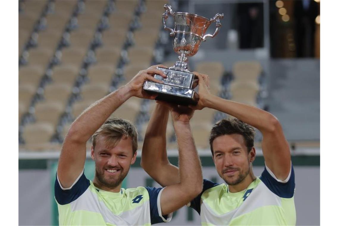 Krawietz und Mies erneut Paris-Sieger Kevin Krawietz (l) und Andreas Mies feiern mit der Trophäe den Finalsieg. Foto: Michel Euler/AP/dpa