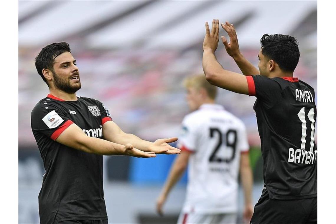 Kevin Volland (l) gewann mit Leverkusen gegen Mainz, verpasste aber dennoch den vierten Tabellenplatz. Foto: Martin Meissner/AP/POOL/dpa