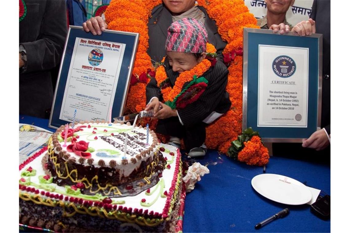 Kleinster beweglicher Mann der Welt gestorben Khagendra Thapa Magar im Jahre 2010 mit der Urkunde vom Guinness-Buch der Rekorde (r). Foto: Narendra Shrestha/epa/dpa