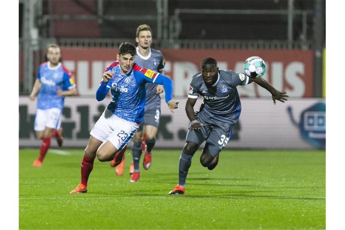 Kiels Janni Serra (l) und Stephan Ambrosius vom HSV kämpfen um den Ball. Foto: Frank Molter/dpa