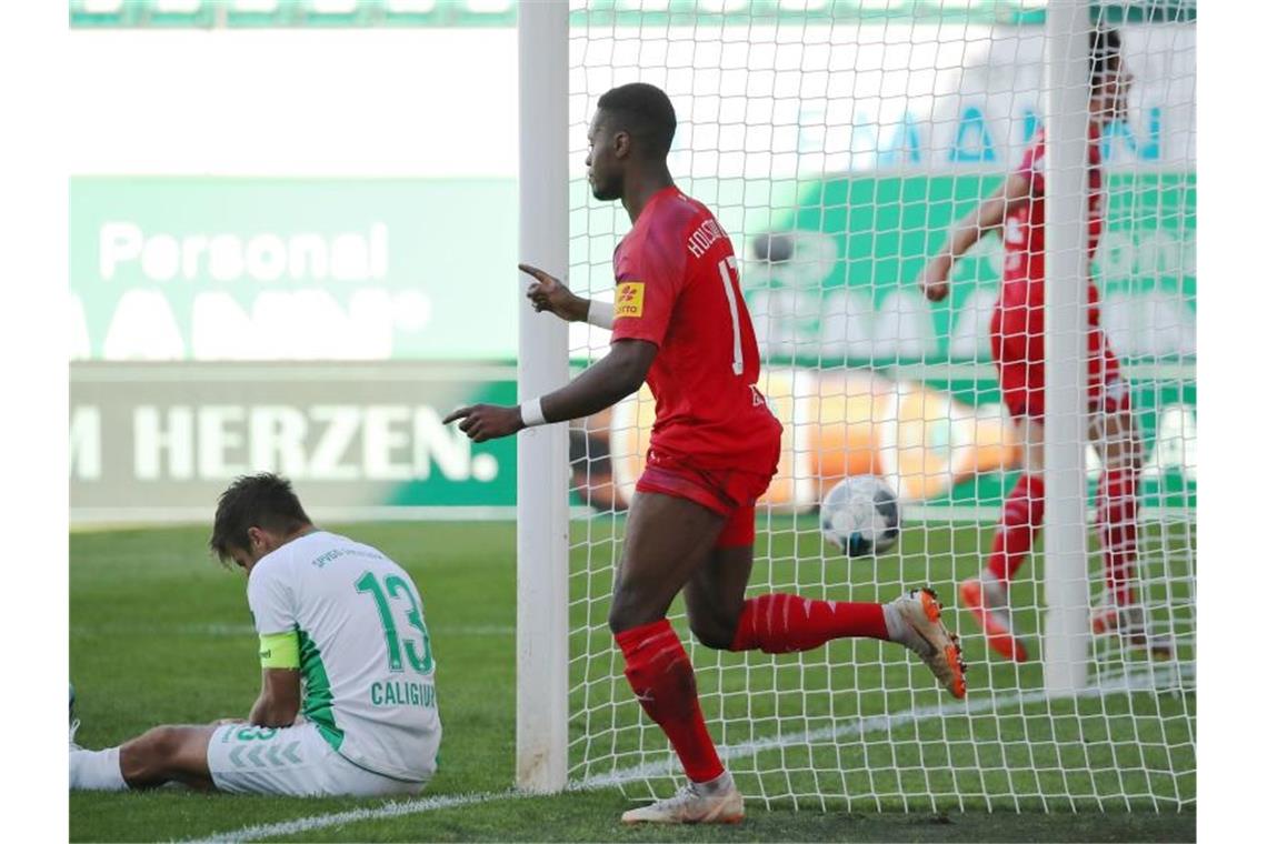 Kiels Makana Baku (M) jubelt über seinen Treffer zum 2:0 neben Marco Caligiuri (l) von der SpVgg Greuther Fürth. Foto: Daniel Karmann