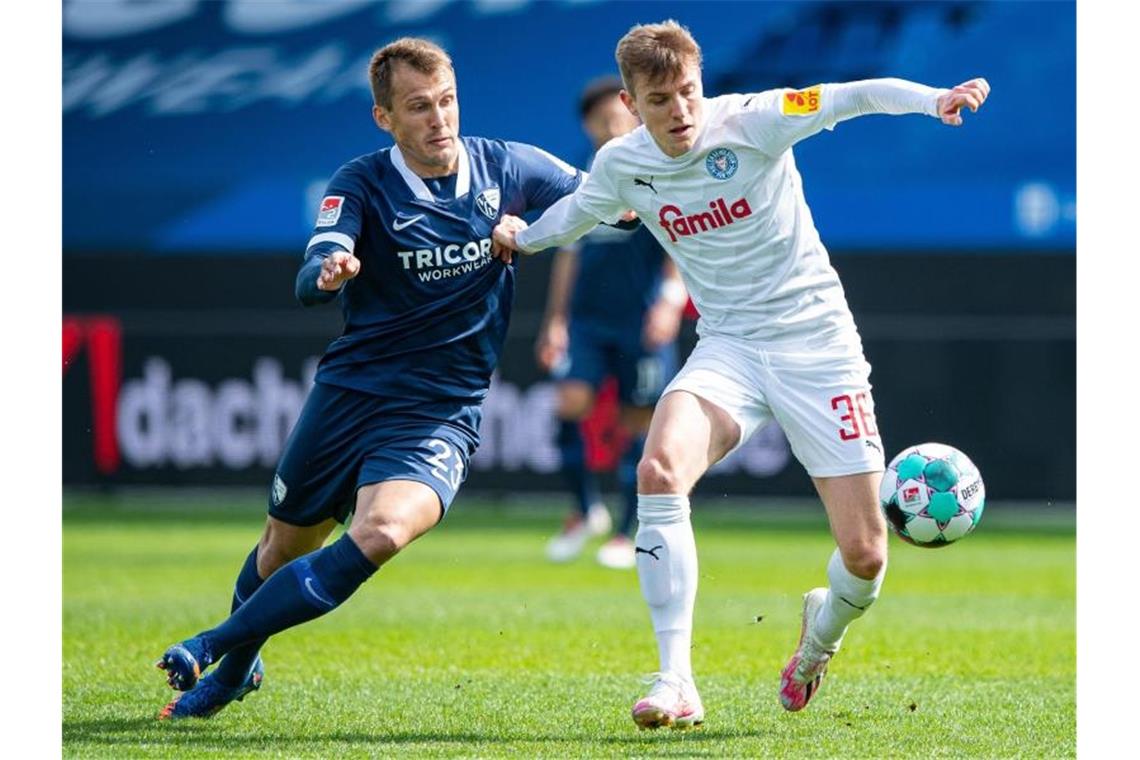 Bochum-Sieg im Spitzenspiel - Osnabrück beendet Negativserie Kiels Niklas Hauptmann (r) und Bochums Robert Tesche kämpfen um den Ball. Foto: Guido Kirchner/dpa