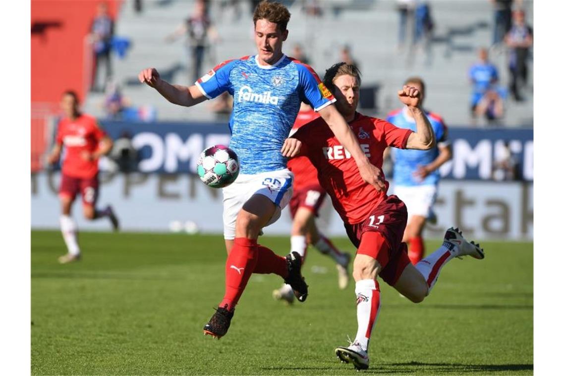 Rettung und Bierdusche: Funkel hält Köln in der Bundesliga Kiels Phil Neumann (l) im Zweikampf mit dem Kölner Florian Kainz. Foto: Carmen Jaspersen/dpa