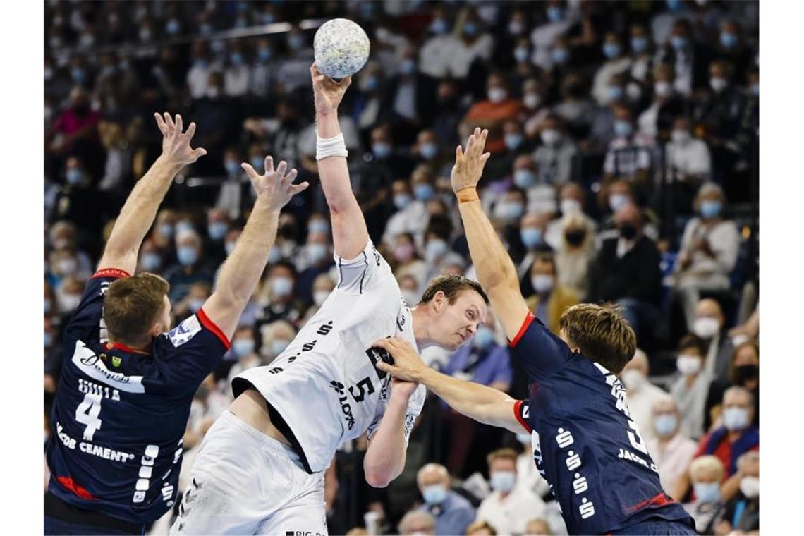 THW Kiel setzt Ausrufezeichen: Kantersieg gegen Flensburg Kiels Sander Sagosen (M) kommt gegen zwei Flensburger zum Wurf. Foto: Frank Molter/dpa
