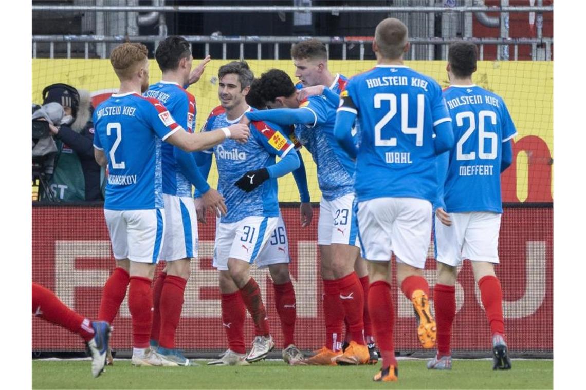 Kiels Spieler feiern Kiels Fin Bartels (3.v.l.) für seinen Treffer zum 2:0 gegen Eintracht Braunschweig. Foto: Axel Heimken/dpa