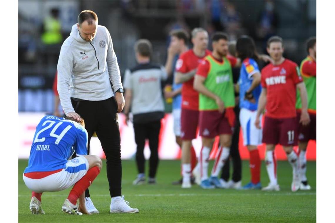 Rettung und Bierdusche: Funkel hält Köln in der Bundesliga Kiels Trainer Ole Werner (2.v.l) tröstet Abwehrspieler Hauke Wahl. Foto: Carmen Jaspersen/dpa