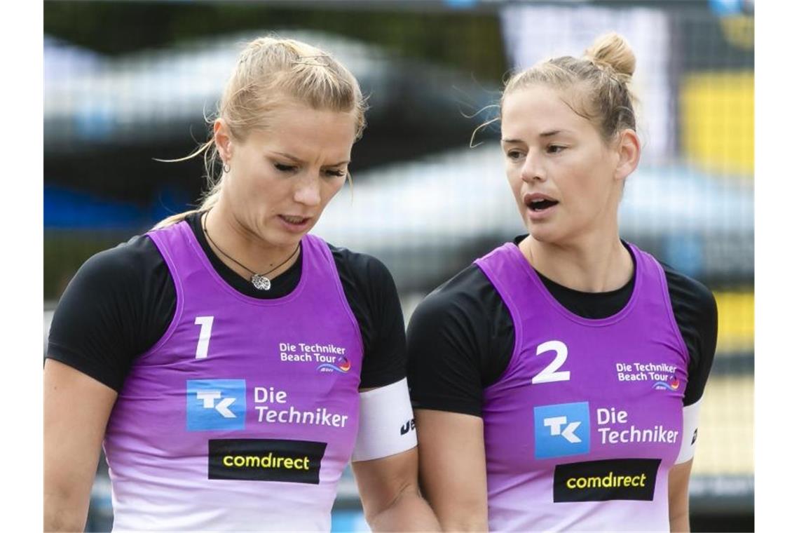 Kim Behrens (l) und Cinja Tillmann unterhalten sich bei den Deutschen Beachvolleyball-Meisterschaften. Foto: Frank Molter/dpa
