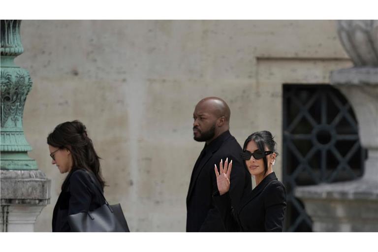 Kim Kardashian winkt in die Kamera, als sie eintrifft, um im Prozess zum Raub von Juwelen in Millionenhöhe aus ihrem Pariser Hotelzimmer im Jahr 2016 auszusagen.