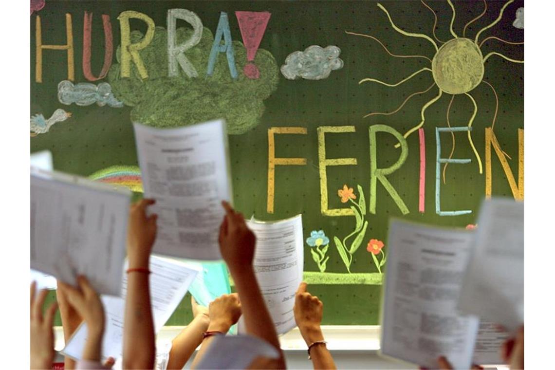 Kinder der vierten Klasse einer Grundschule in Kaufbeuren jubeln vor einer Tafel mit der Aufschrift „Hurra Ferien“. Foto: Karl-Josef Hildenbrand/dpa