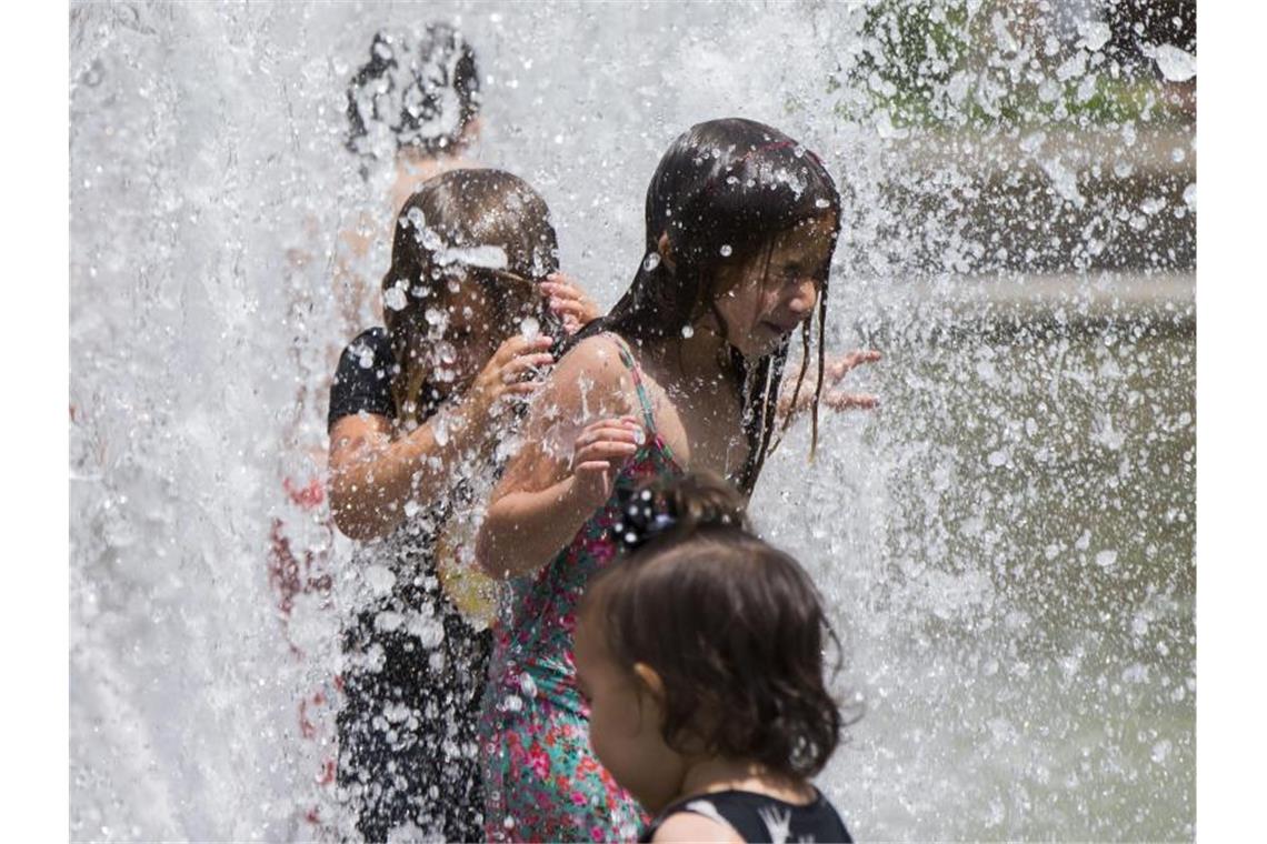 Feuer im Westen Nordamerikas brennen weiter Kinder erfrischen sich im kanadischen Toronto in einem Brunnen. Foto: Zou Zheng/XinHua/dpa