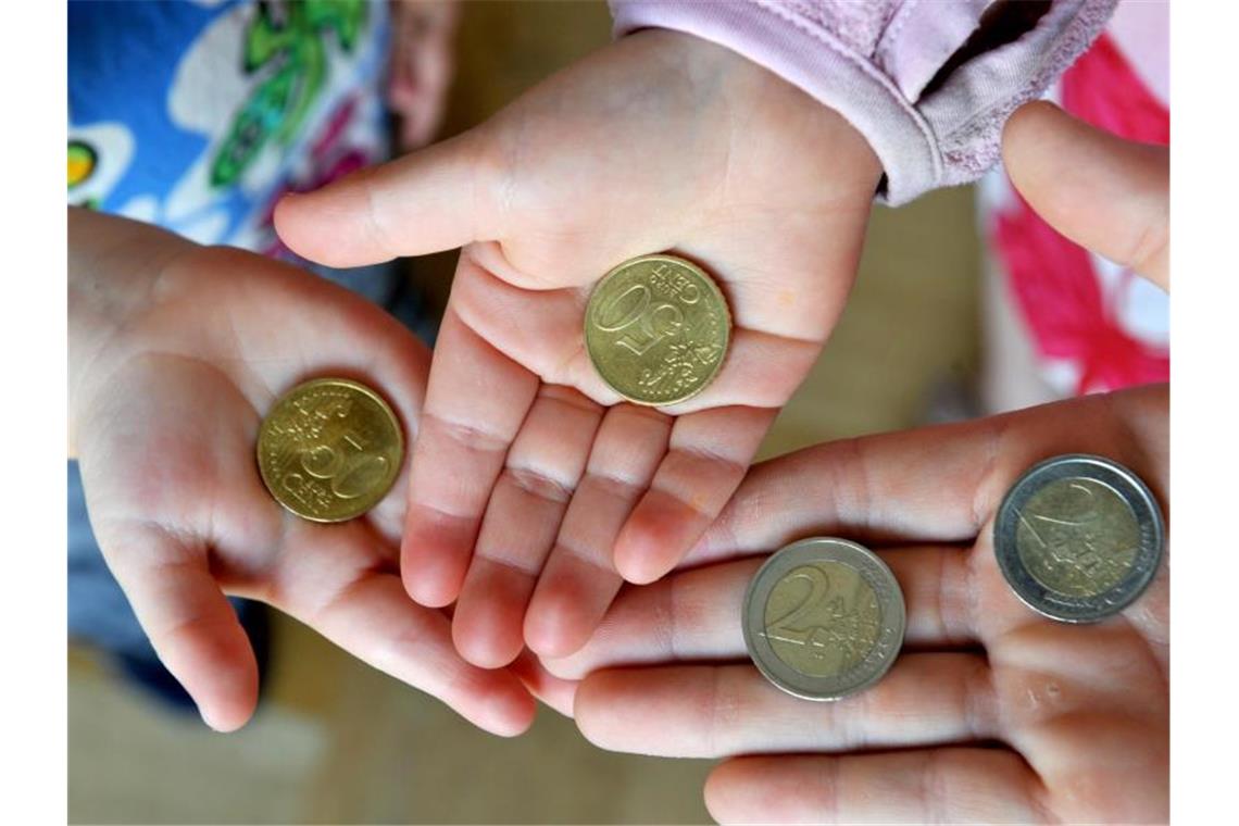 Kinder halten Euro-Münzen in den Händen. Foto: Patrick Seeger/dpa/dpa-tmn/Symbolbild